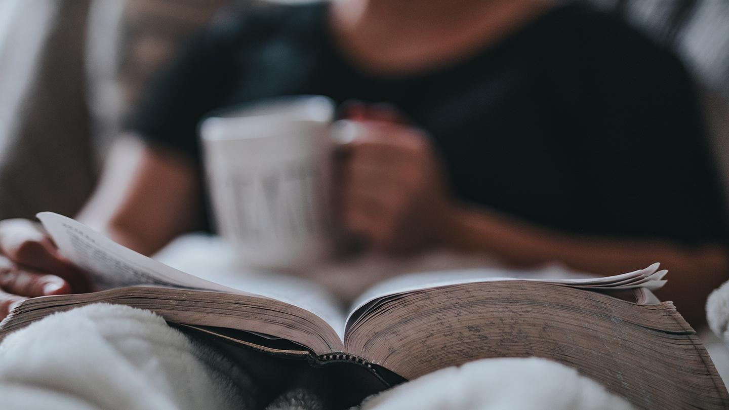 Woman drinking her coffee in bed